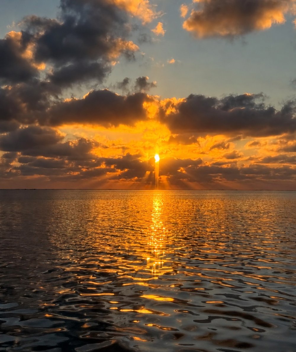 佐和田の浜で雲の間から光が差す夕日